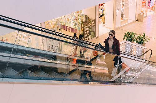 woman riding escalator